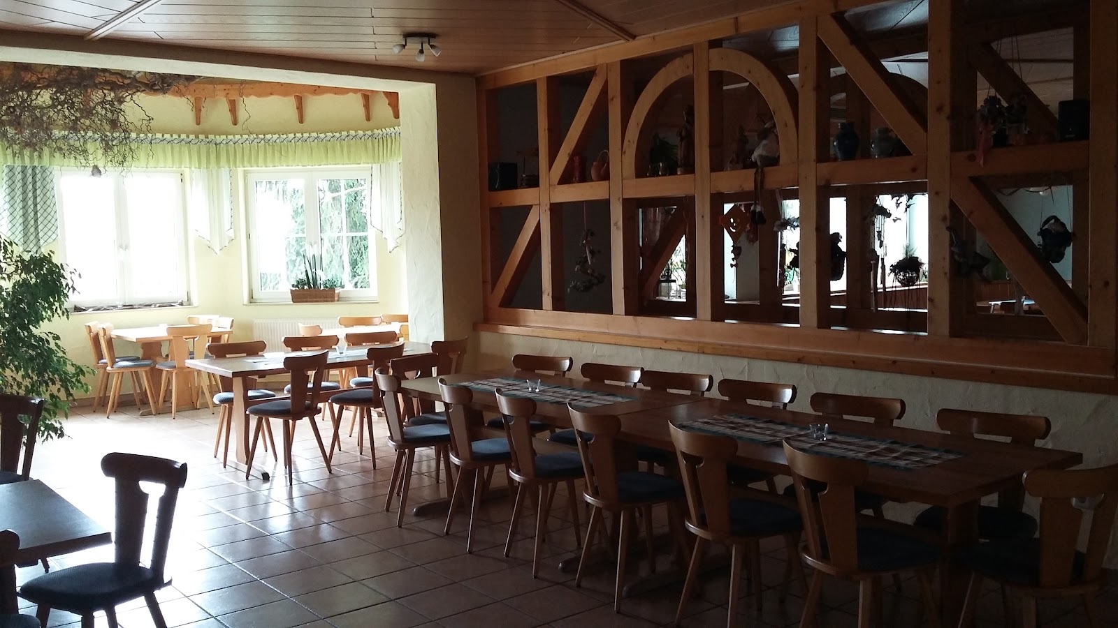 Der Nebenraum mit langer gedeckter Tafel unter offenem Fachwerk